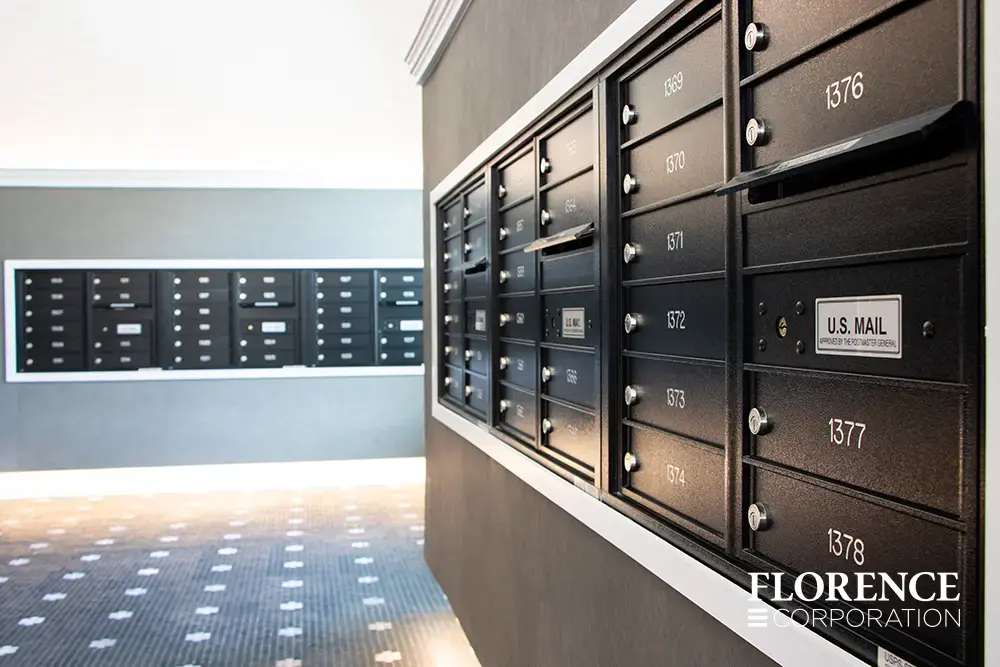 Recessed mount versatile™ 4C mailboxes in black installed in multifamily apartment building modern mailroom with tile floor