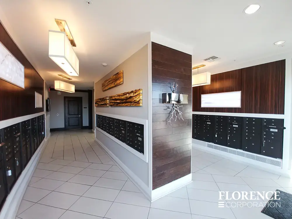 Recessed mount versatile™ 4C mailboxes in black installed in contemporary mail room with wood accents and modern light fixture