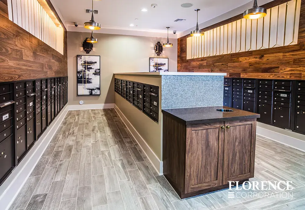 Recessed mount versatile™ 4C mailboxes in black installed in contemporary mail room with wood accents, vinyl flooring, and modern light fixtures
