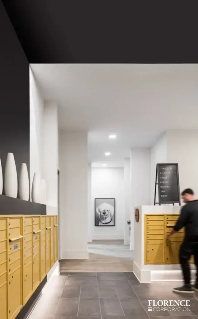 Recessed mount versatile™ 4C mailboxes in gold speck in modern mailroom with white and black accents and man checking his mail