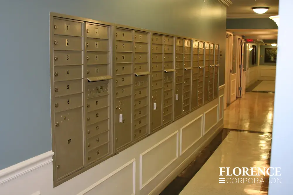 Recessed mount versatile™ 4C mailboxes in silver speck installed indoor in dark multifamily apartment building first floor hallway