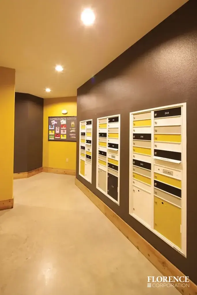 Recessed mount versatile™ 4C mailboxes with multiple colored compartment doors installed in residential hallway with brown and yellow walls