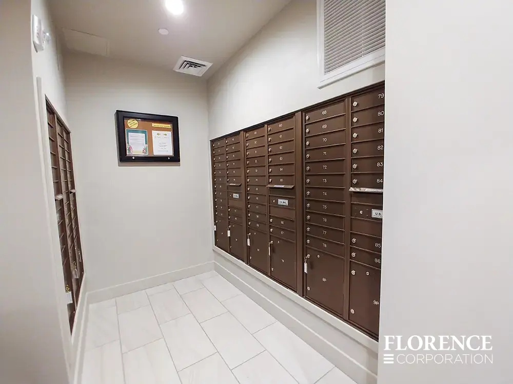 Recessed mount versatile™ 4C mailboxes in antique bronze installed in mailroom with white walls, trim and tile floor
