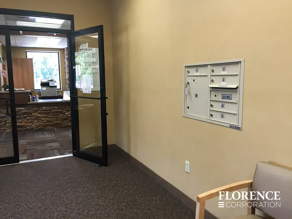 Recessed mount versatile™ 4C mailboxes in sandstone installed on cream wall of commercial building