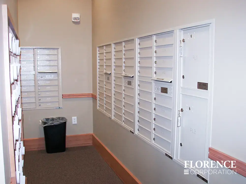 Recessed mount versatile™ 4C mailboxes and parcel lockers in white installed in commercial building