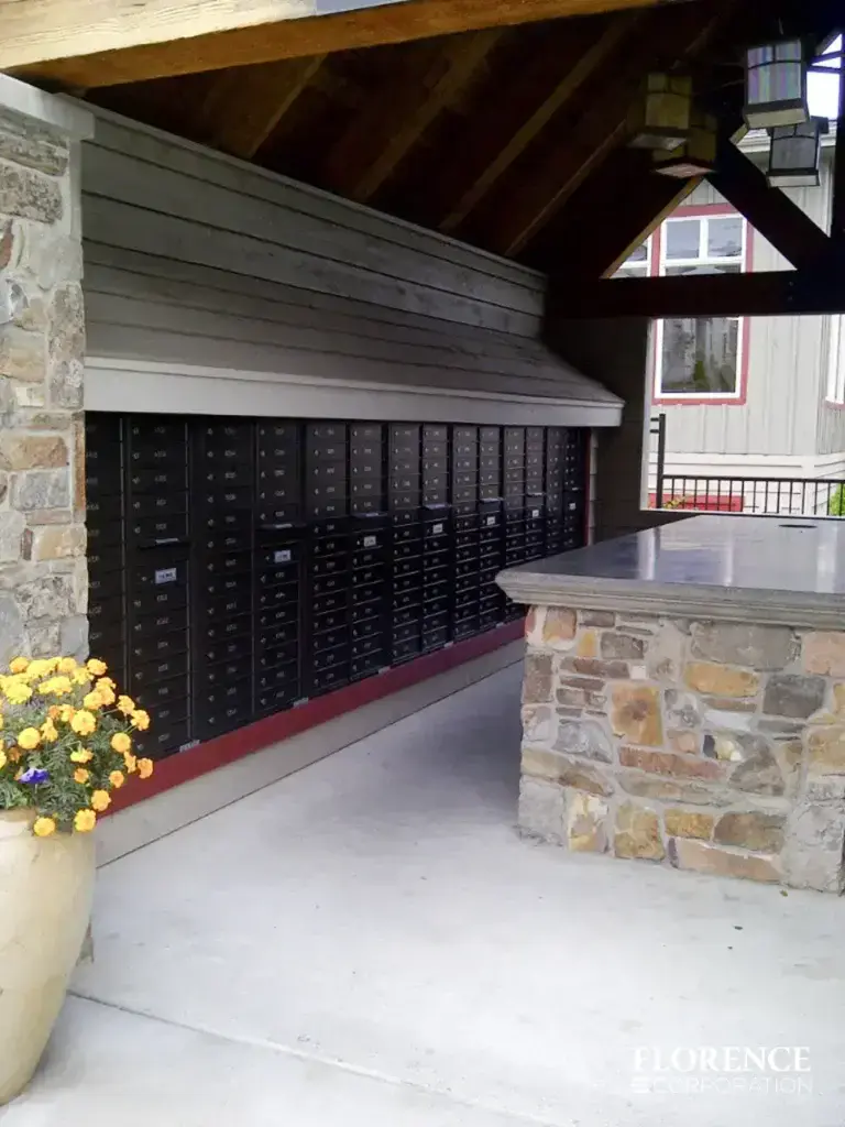 recessed mounted versatile™ 4C mailboxes in black installed outdoor under covered gazebo with floral planters and stone column