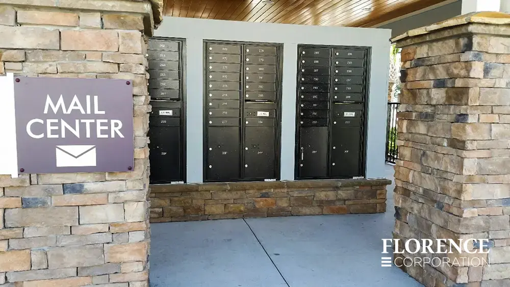 recessed mounted versatile™ 4C mailboxes in black mounted on stone foundation under covered open air mail center
