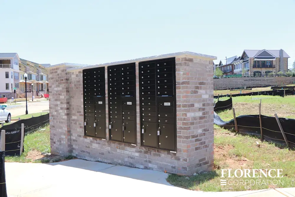 recessed mounted versatile™ 4C mailboxes in black placed in brick of new construction community