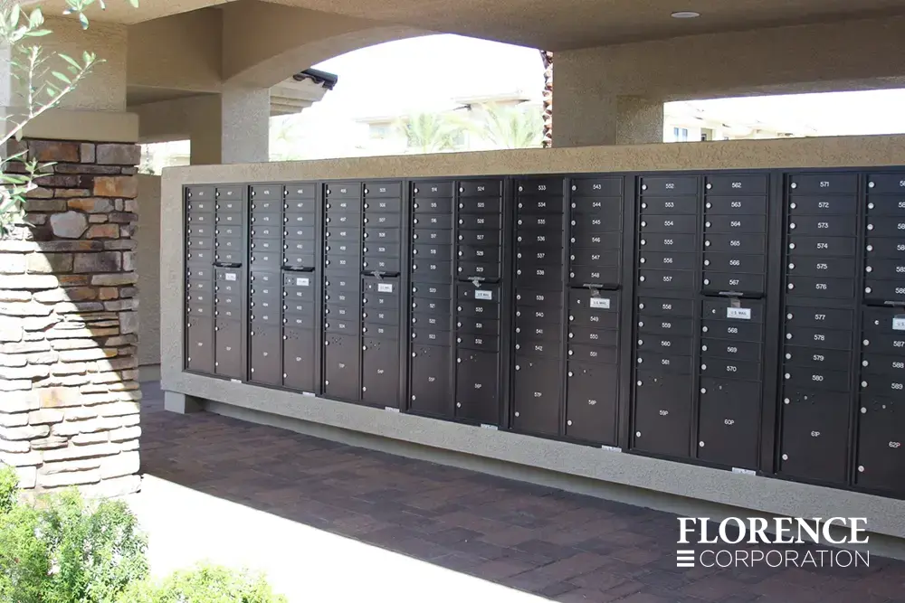 recessed mounted versatile™ 4C mailboxes in black mounted in cream stucco near stone column in covered area