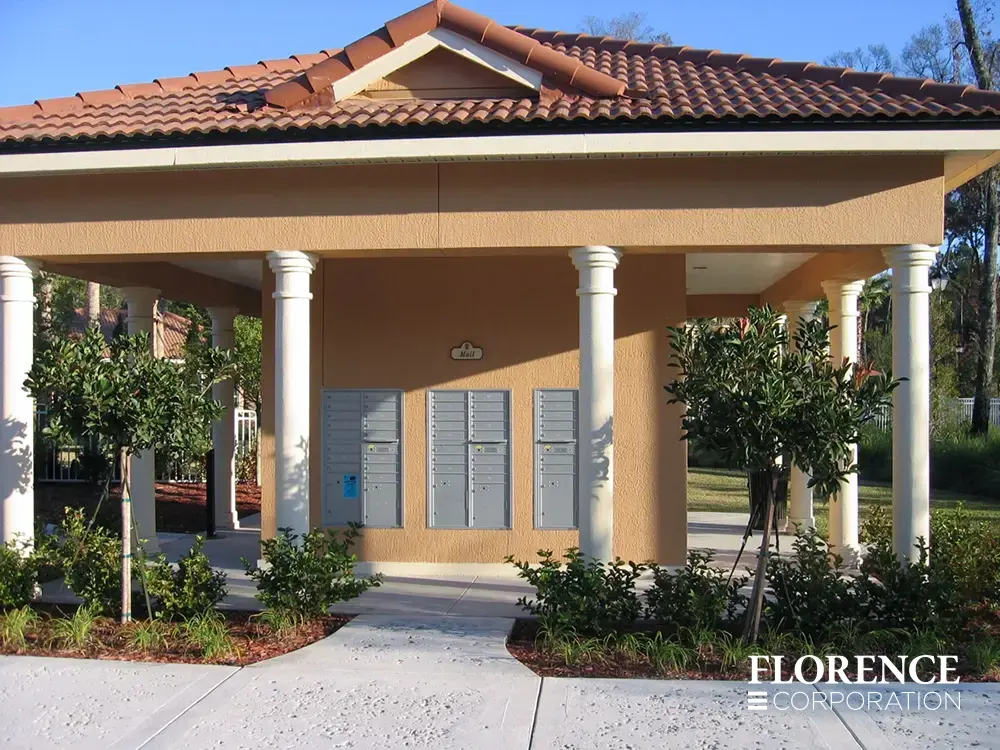 recessed mounted versatile™ 4C mailboxes in silver speck installed outdoors under orange spanish tile pavilion surrounded by green landscaping