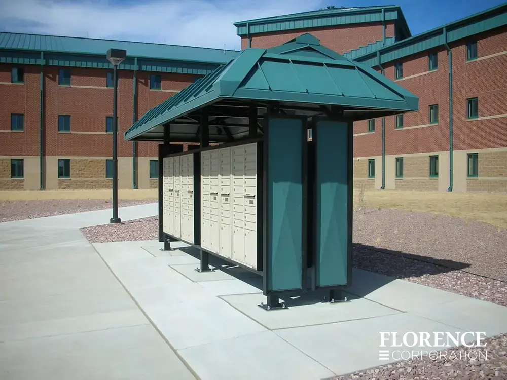 recessed mounted versatile™ 4C mailboxes in sandstone installed in green metal weather protected fixture outside of red brick commercial building