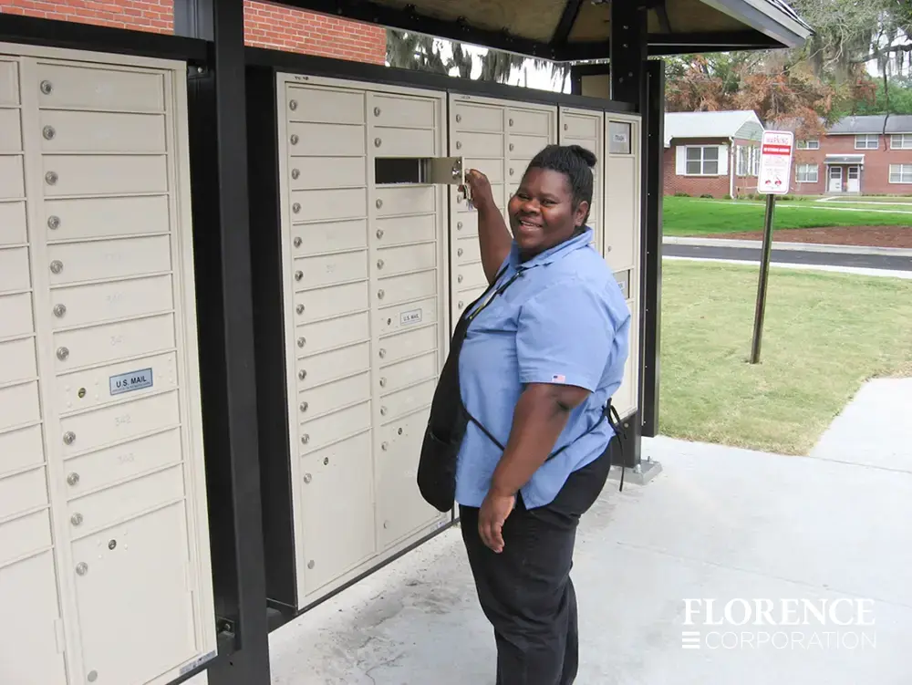 recessed mounted versatile™ 4C mailboxes in sandstone with smiling African American women retrieving mail
