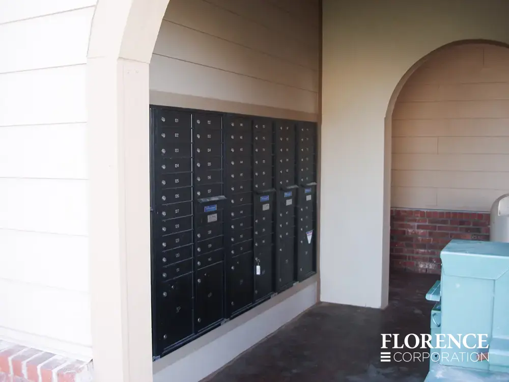 recessed mounted versatile™ 4C mailboxes in black in cream breezeway of multifamily apartment community building