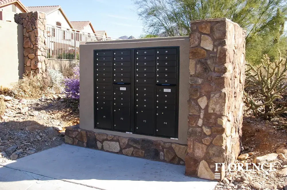 recessed mounted versatile™ 4C mailboxes in black installed in outdoor stone fixture in townhome community