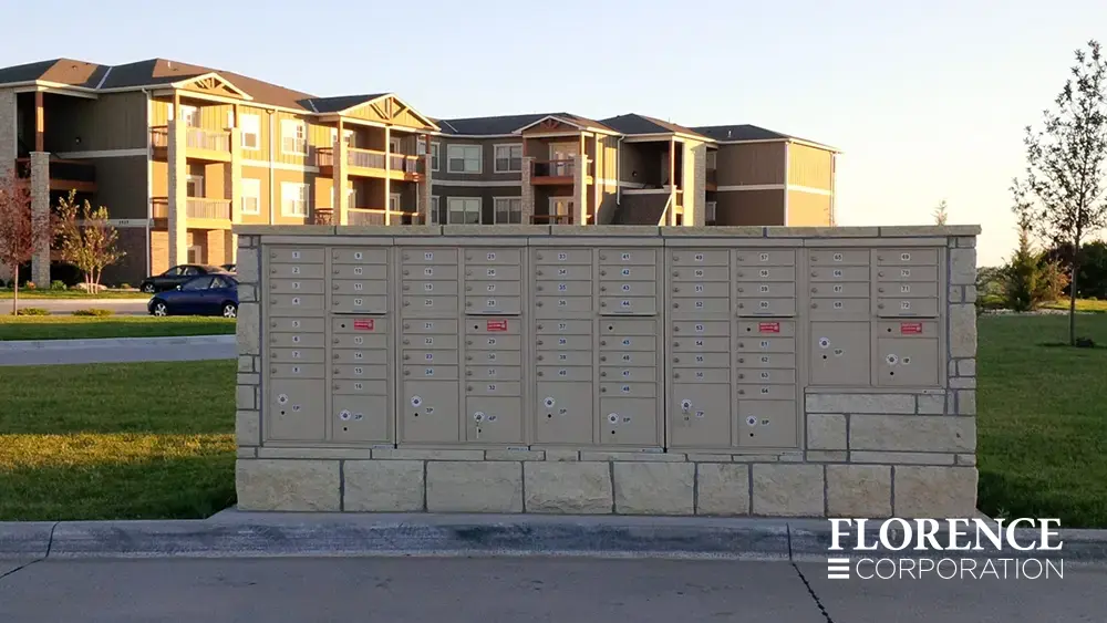 recessed mounted versatile™ 4C mailboxes in sandstone installed in rock fixture in parking lot area of multifamily apartment community