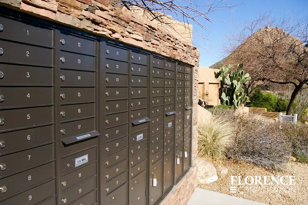 recessed mounted versatile™ 4C mailboxes in dark bronze installed in outdoor stone fixture in desert landscape with cactus and desert shrubbery