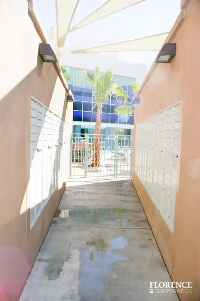 recessed mounted versatile™ 4C mailboxes in white installed in outdoor walls of walkway to pool area of multifamily apartment building