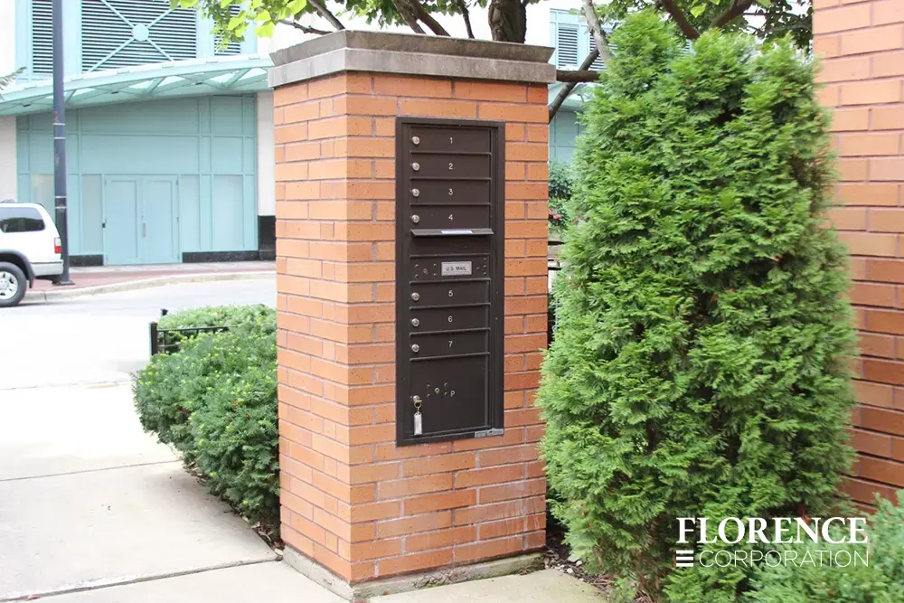 single recessed mounted versatile™ 4C mailbox module in dark bronze installed in brick pillar outside commercial space
