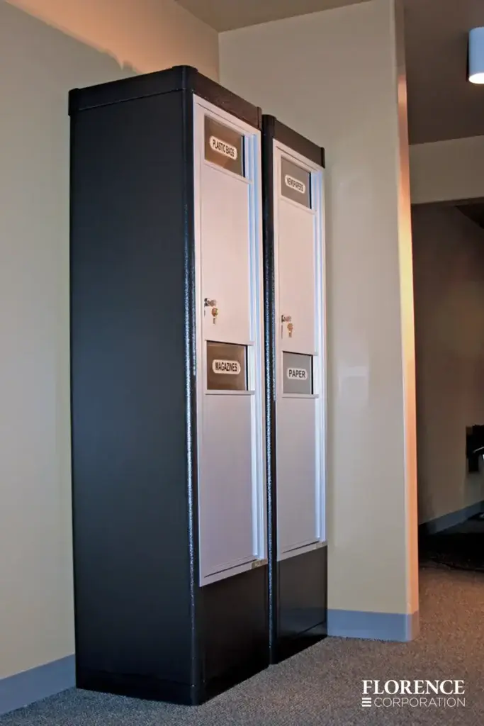 versatile™ 4C waste and recycling bins installed in black freestanding depot cabinets side by side inside of commercial space on carpeted floor