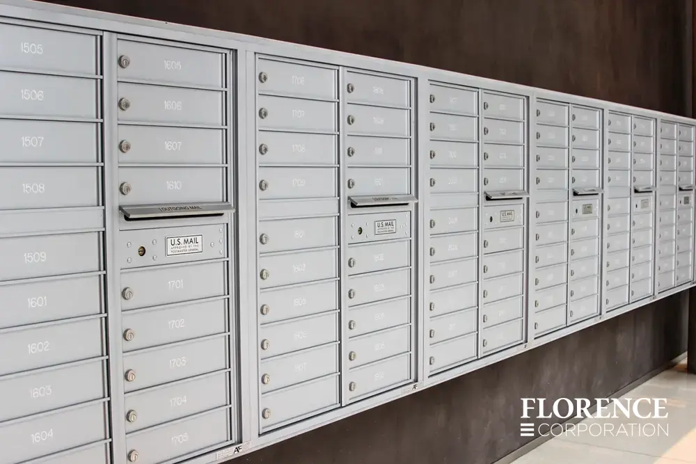 row of surface mounted versatile™ 4C mailboxes in silver speck mounted on dark wall in commercial building lobby space