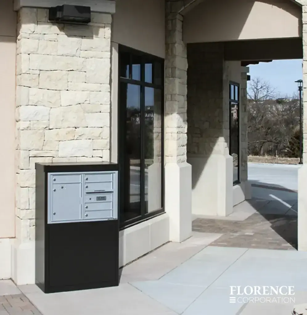 versatile™ 4C mailbox installed in freestanding depot cabinet outside of stone commercial building in mid winter